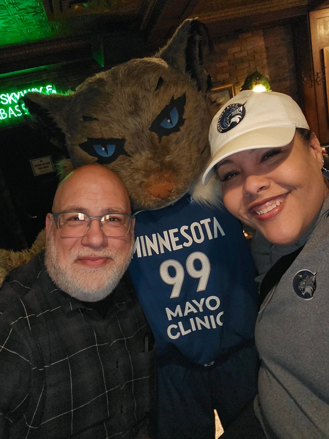 Amanda Matchett with a wolf mascot at a Minnesota Timberwolves event